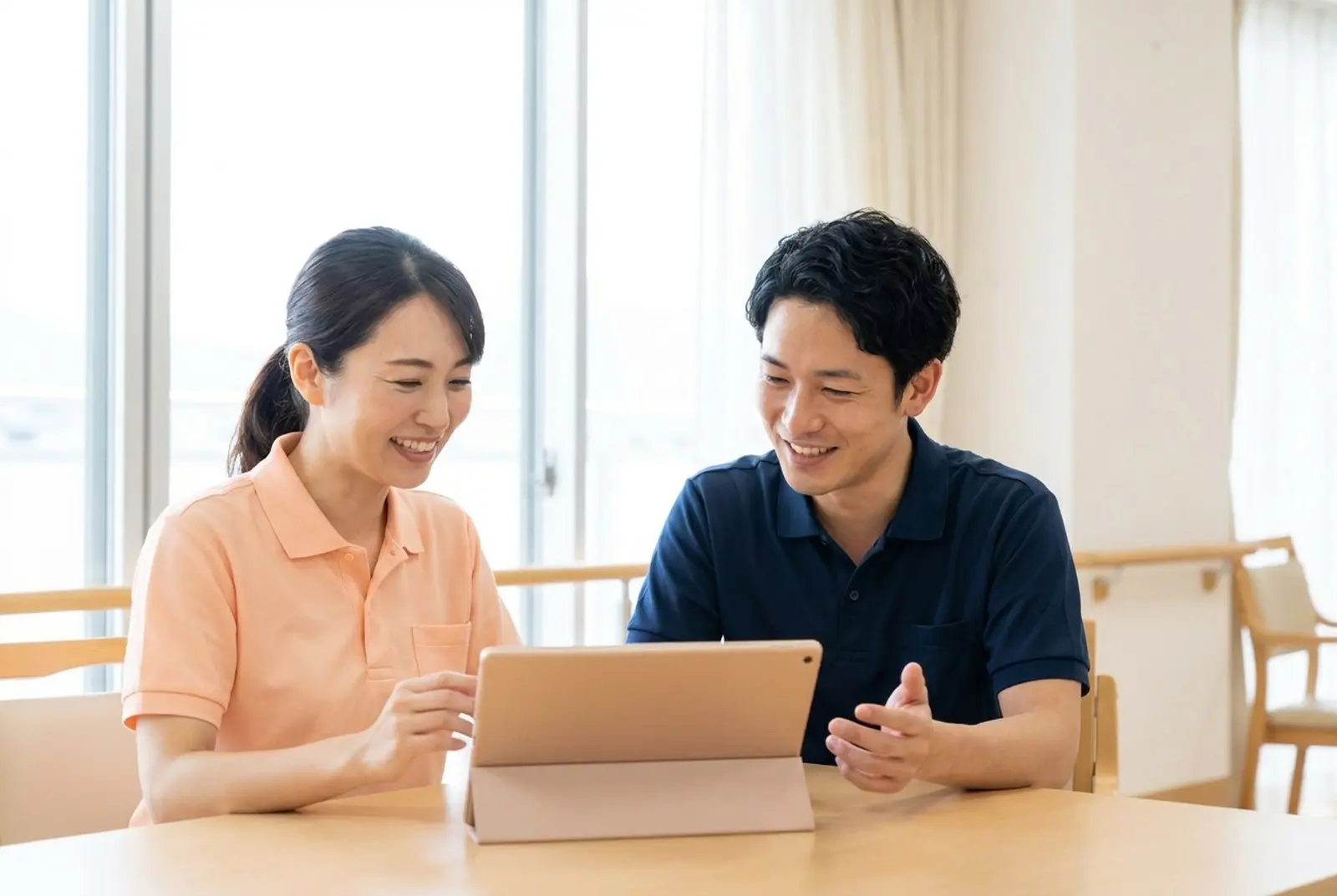 タブレットを見ながら話す介護職員